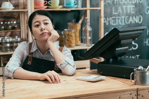 Canvas Print startup business owner woman waiting for customers leaning on bar counter with hands on chin