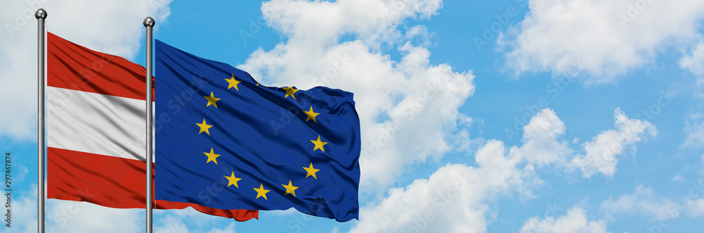 Austria and European Union flag waving in the wind against white cloudy blue sky together. Diplomacy concept, international relations. Austria and European Union flag waving in the wind against white cloudy blue sky together. Diplomacy concept, international relations.