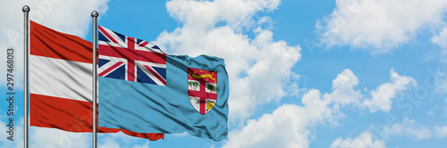 Austria and Fiji flag waving in the wind against white cloudy blue sky together. Diplomacy concept, international relations.