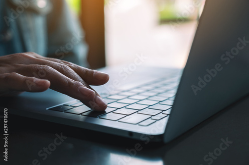 Closeup image of a woman typing and pressing finger on laptop computer keyboard