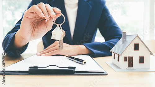 Model domu z agentem nieruchomości i klientem omawiającym umowę na zakup domu, ubezpieczenia lub pożyczki nieruchomości.
