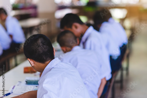 The Asian high school students in white uniform are studying in the classroom.