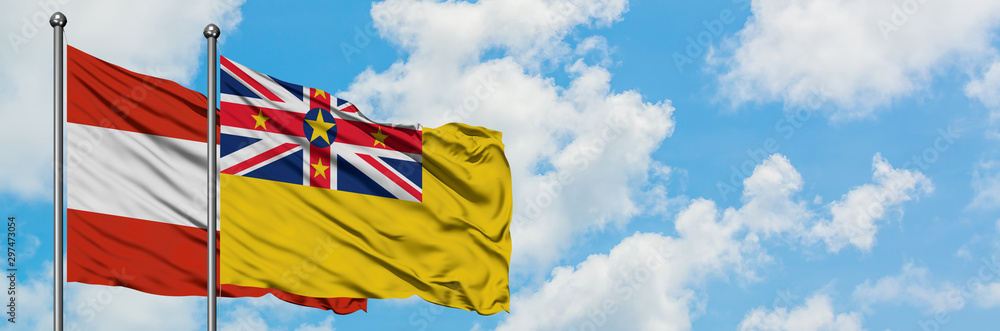 Austria and Niue flag waving in the wind against white cloudy blue sky together. Diplomacy concept, international relations. Austria and Niue flag waving in the wind against white cloudy blue sky together. Diplomacy concept, international relations.