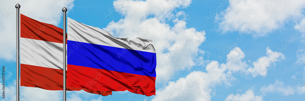 Naklejka premium Austria and Russia flag waving in the wind against white cloudy blue sky together. Diplomacy concept, international relations.