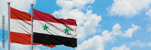Austria and Syria flag waving in the wind against white cloudy blue sky together. Diplomacy concept, international relations.