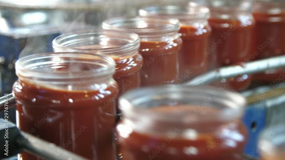 Smoking tomato paste banks rolling on a metallic line without lids in tomato factory Smoking tomato paste banks rolling on a metallic line without lids in tomato factory