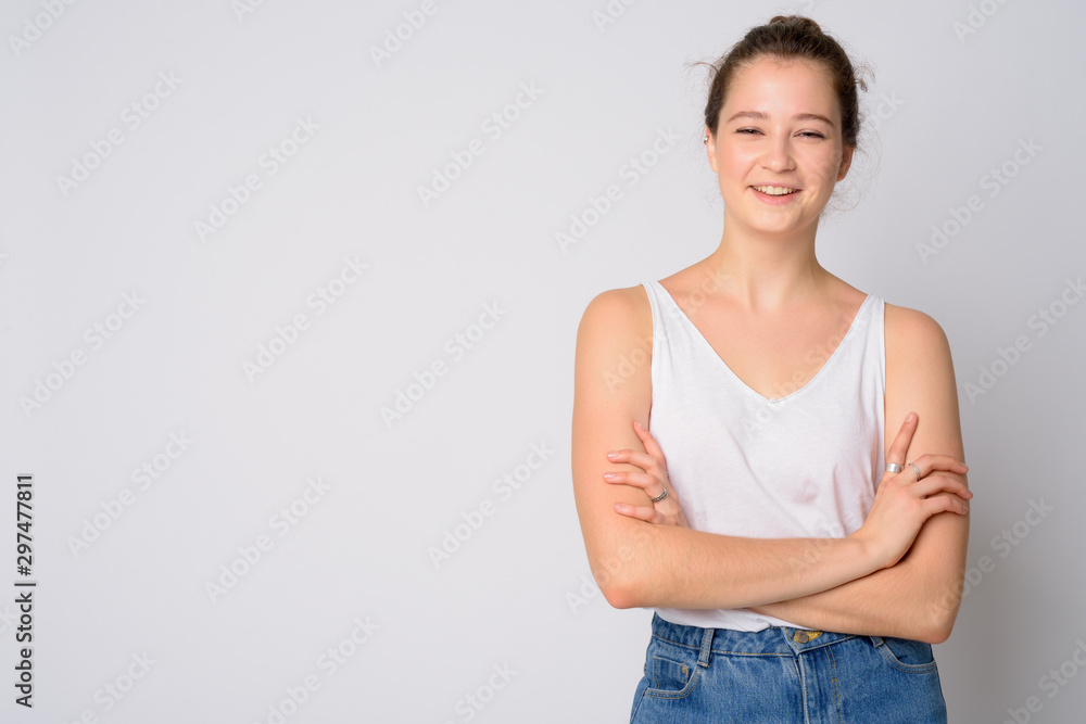 Portrait of happy young beautiful woman smiling with arms crossed