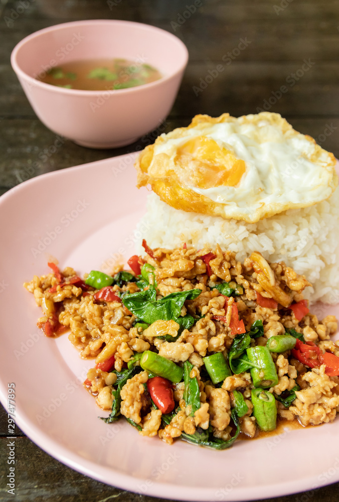 Stir fried chicken with holy basil leaves served with fried egg and steamed rice