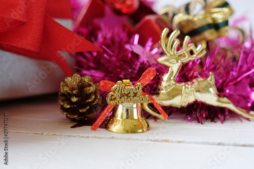 Close up gold bell with text 'Merry christmas" and x'mas party decorations on wooden background. Selected focus.