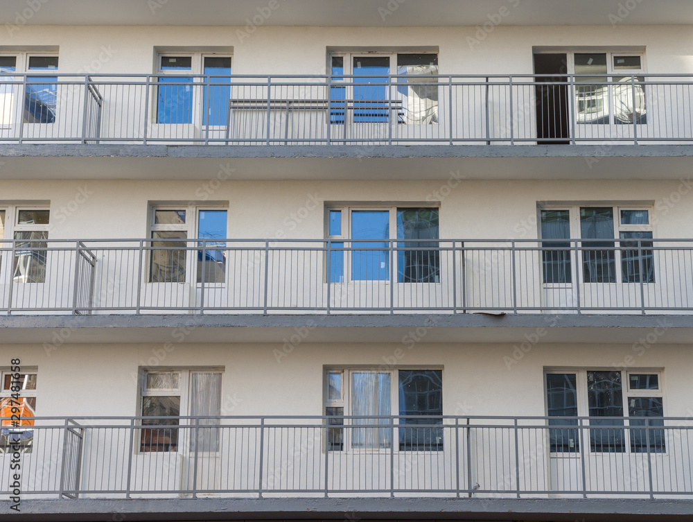 A fragment of the wall of a residential building under construction. Windows and balconies. The theme of an emerging housing market under construction