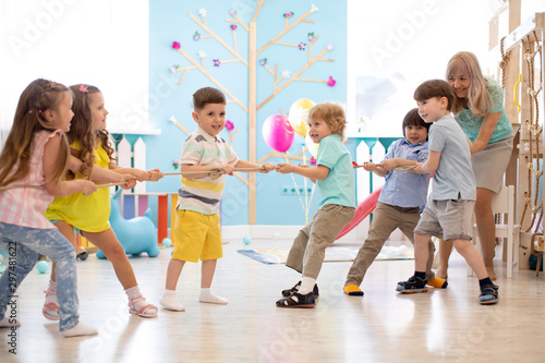 Group of children in a rope-pulling contest indoors