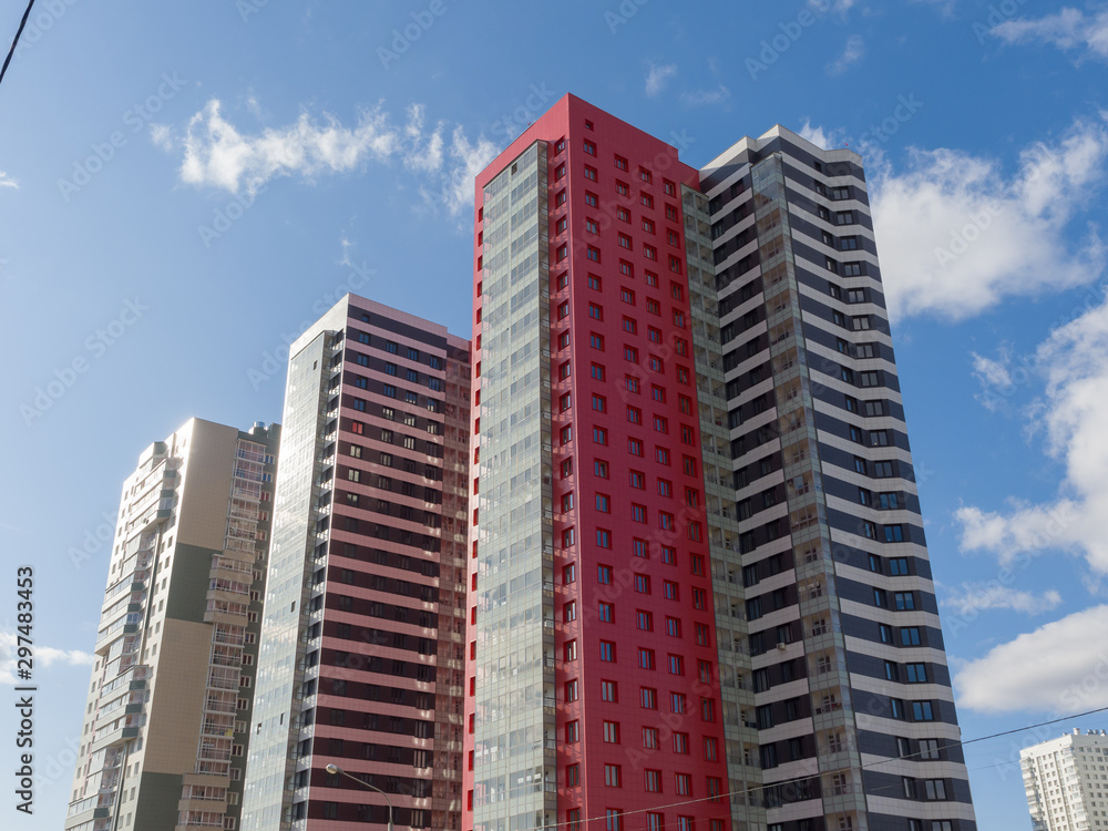 New beautiful residential high-rise buildings in the blue sky. The theme of an emerging housing market under construction New beautiful residential high-rise buildings in the blue sky. The theme of an emerging housing market under construction