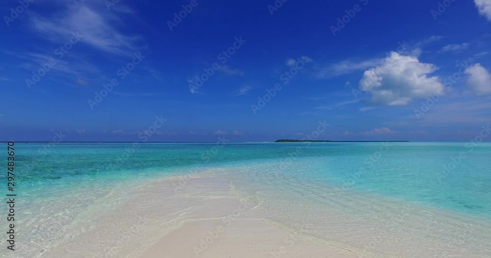 Tropical beach with white sand in Bali, Indonesia, with waves gently breaking on the shore Tropical beach with white sand in Bali, Indonesia, with waves gently breaking on the shore