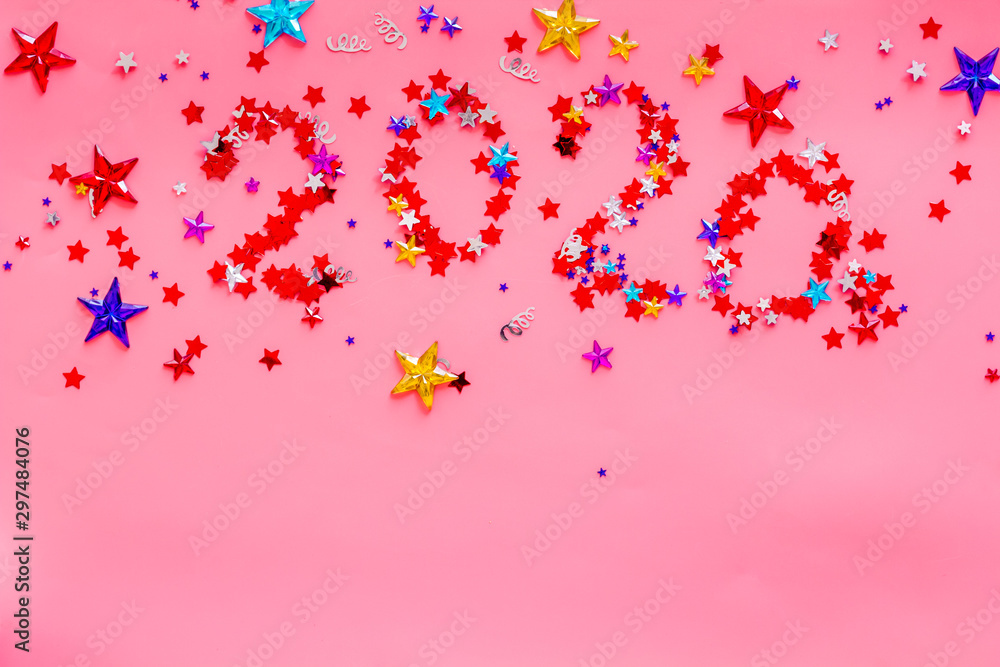 Celebrate New Year 2020. Date on confetti near champagne bottle on pink background top view copy space