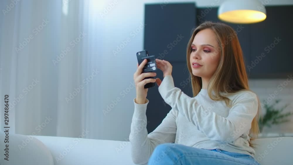 The girl orders dresses in the online store using a smartphone and a credit card. Easy online shopping The girl orders dresses in the online store using a smartphone and a credit card. Easy online shopping