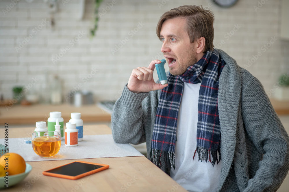 Man using inhalator while suffering from asthma Man using inhalator while suffering from asthma