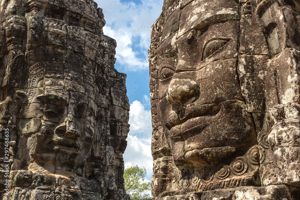 Faces carved in stone in Bayon temple towers, Angkor Wat complex, Cambodia, Siem Reap Faces carved in stone in Bayon temple towers, Angkor Wat complex, Cambodia, Siem Reap