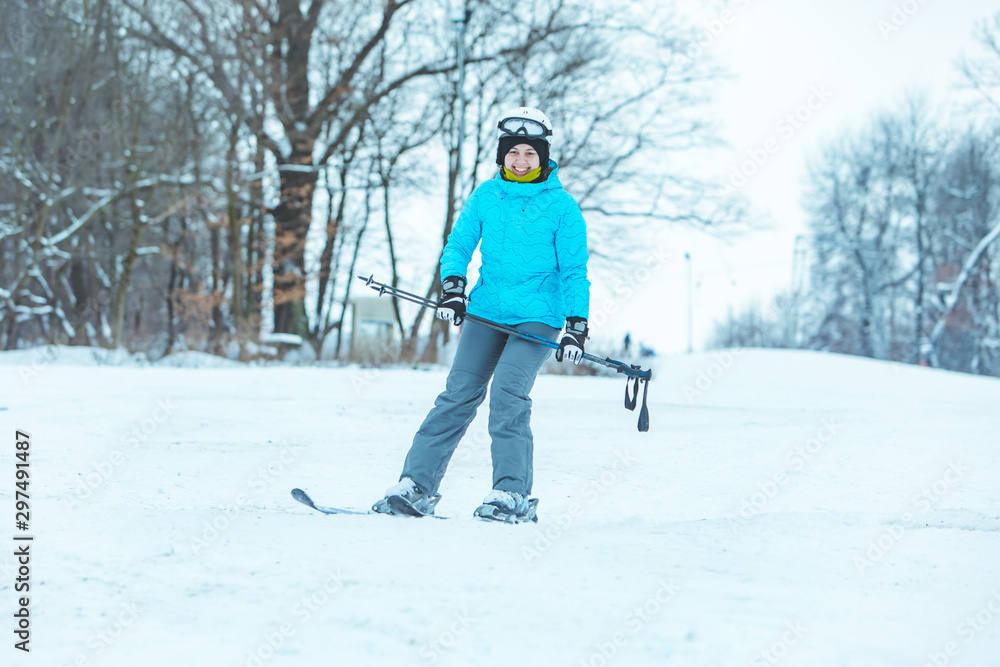 young adult smiling woman skiing down by hill