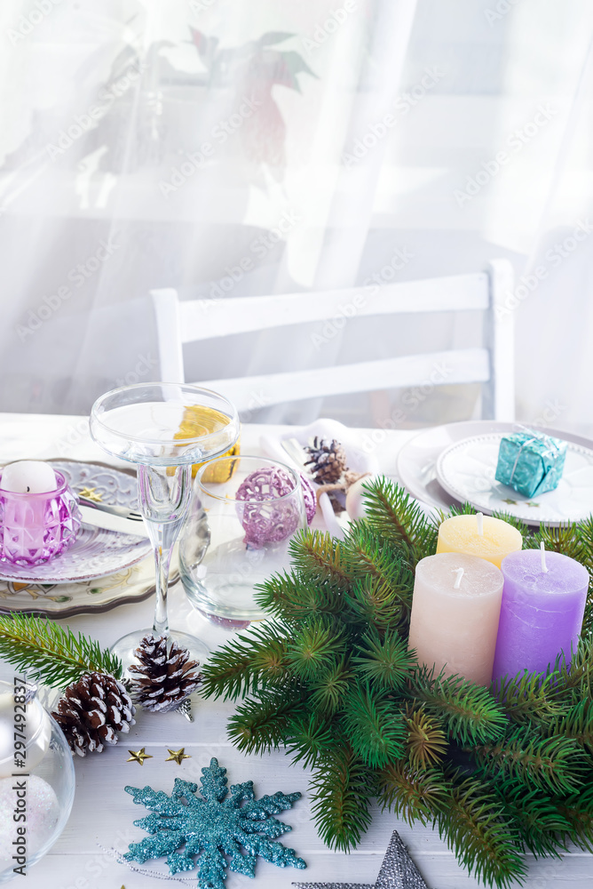 Place table setting for Christmas white table with purple decor elements and green wreath Christmas tree Place table setting for Christmas white table with purple decor elements and green wreath Christmas tree