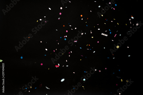 colorful party confetti flying in front of black