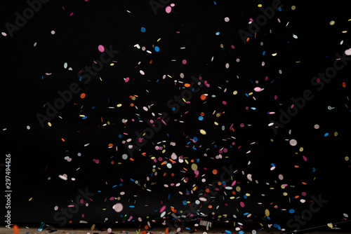 colorful party confetti flying in front of black