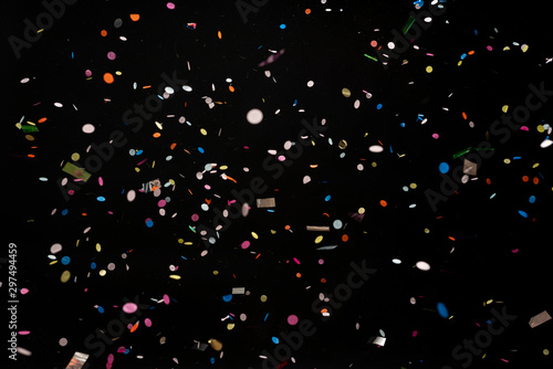 colorful party confetti flying in front of black