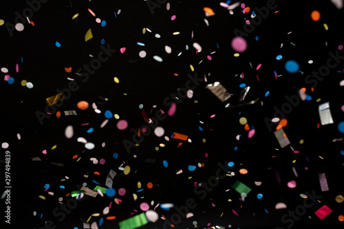 colorful party confetti flying in front of black