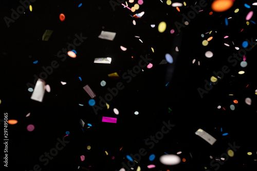 colorful party confetti flying in front of black