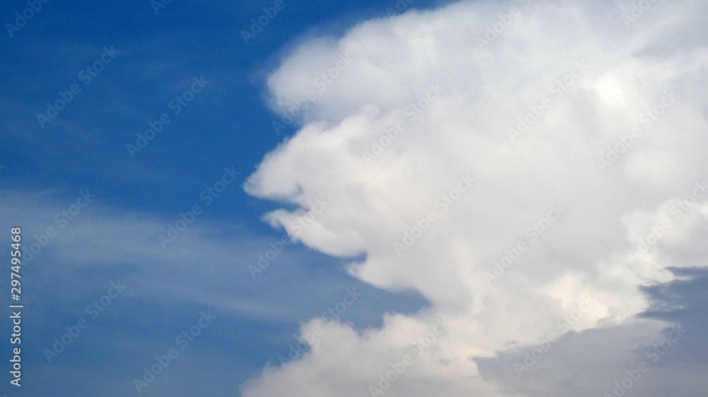 Obraz premium Large white cloud against blue sky