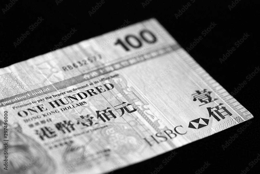 One hundred Hong Kong dollars banknote on a dark background close up. Black and white One hundred Hong Kong dollars banknote on a dark background close up. Black and white