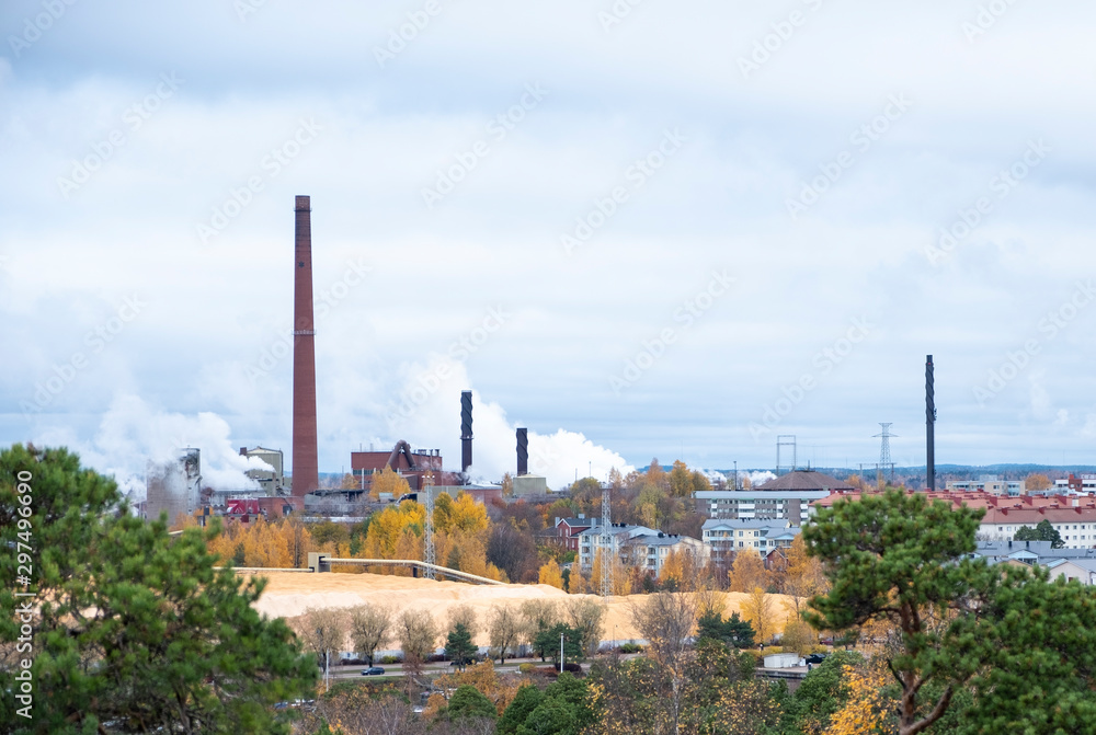 Cityscape, red brick buildings of an old factory, factory chimneys smoke. Ecology problems in Europe.