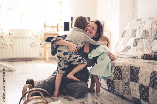 happy mom with two children on the floor in room photo