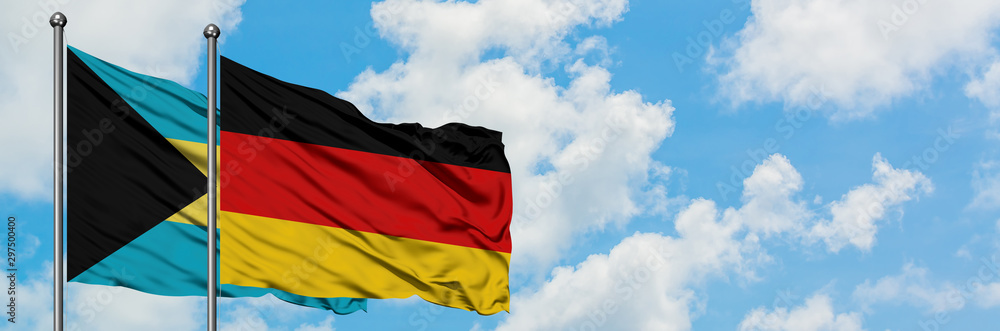 Bahamas and Germany flag waving in the wind against white cloudy blue sky together. Diplomacy concept, international relations. Bahamas and Germany flag waving in the wind against white cloudy blue sky together. Diplomacy concept, international relations.