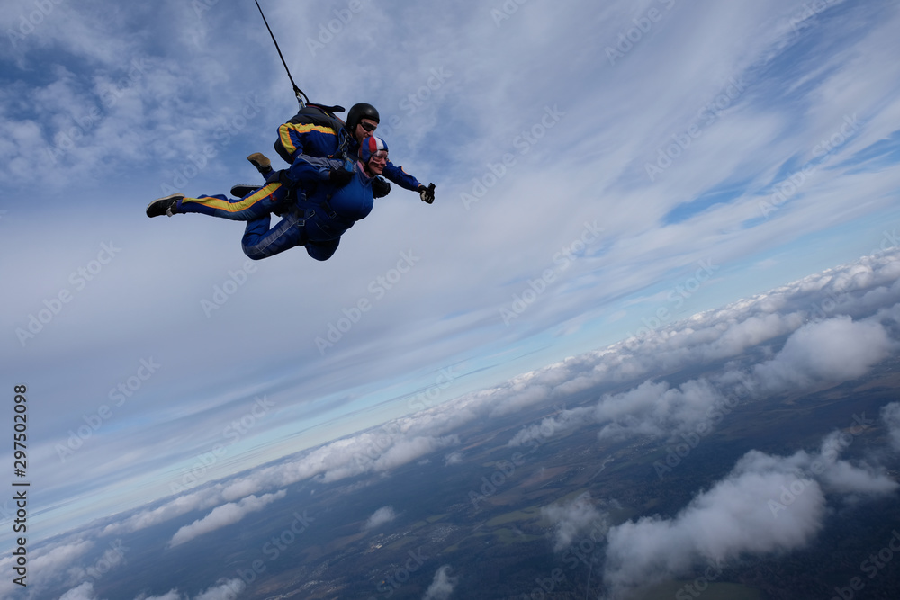 Skydiving. Tandem jump. Two skydivers are in the sky.