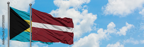 Bahamas and Latvia flag waving in the wind against white cloudy blue sky together. Diplomacy concept, international relations.