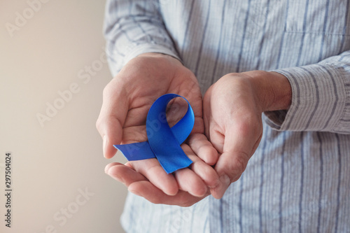 Man Hands holding blue ribbon, Prostate Cancer Awareness, November blue, Movember Men health awareness, world diabetes day