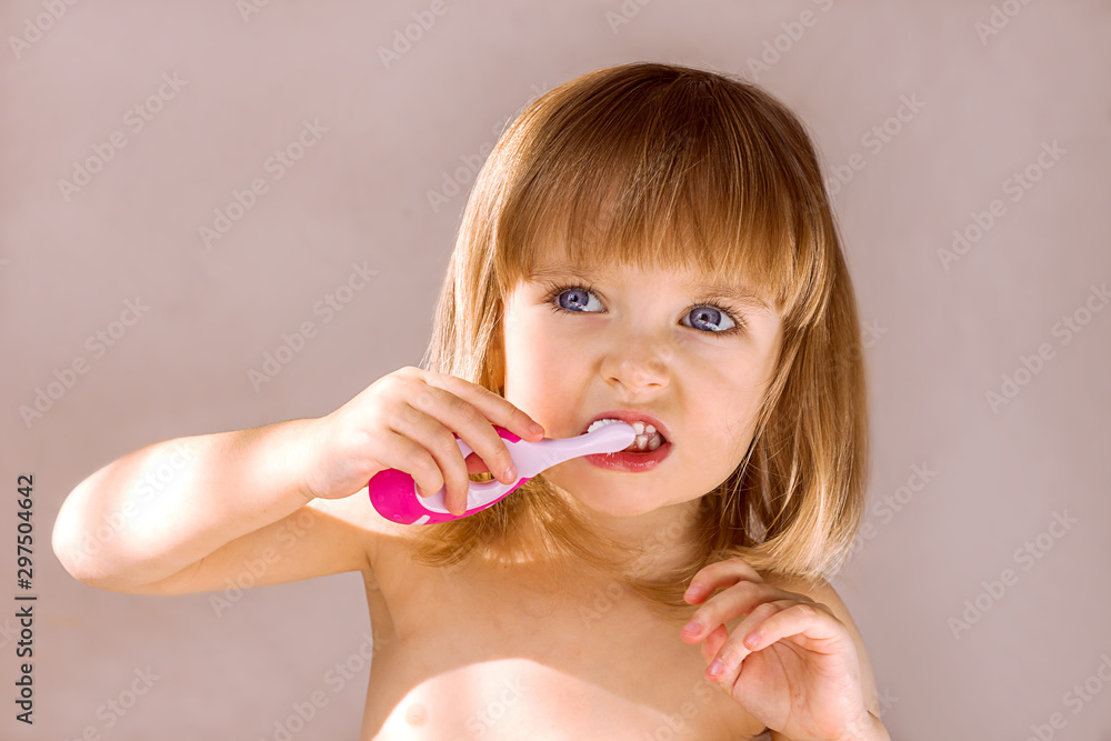 Happy baby girl brushing her teeth. Oral hygiene concept. Place to insert text Happy baby girl brushing her teeth. Oral hygiene concept. Place to insert text