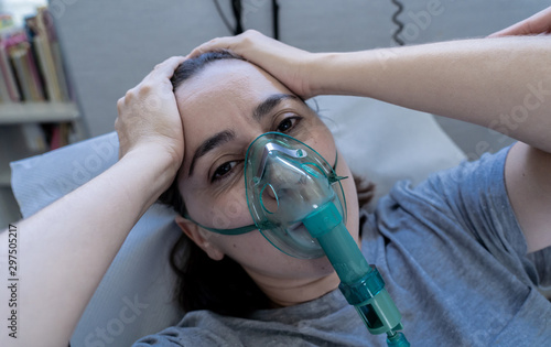 Sick woman with oxygen mask in emergency room at hospital