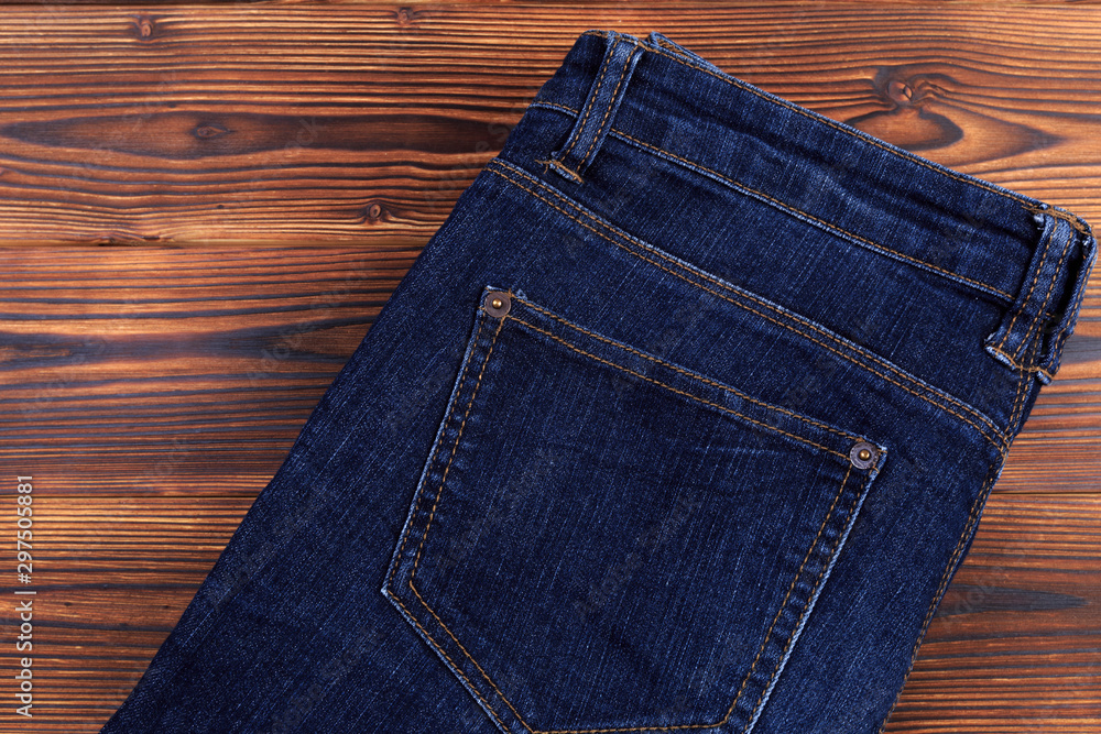 blue denim jeans on wooden background . blue denim jeans on wooden background .