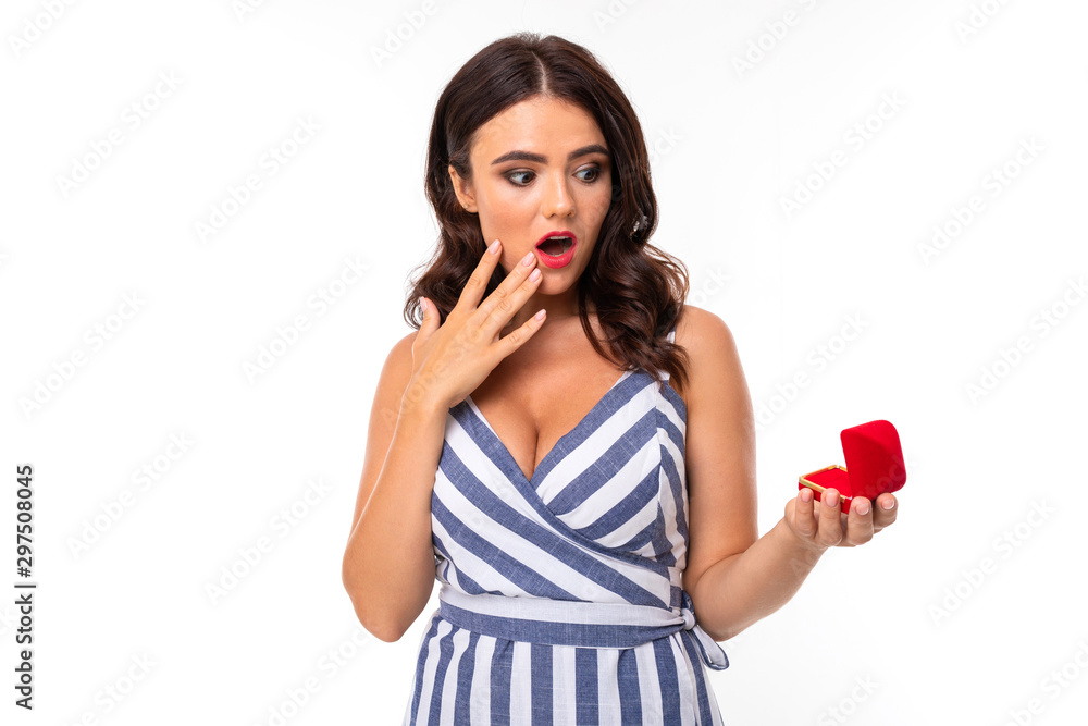 A young girl with a delightful smile, flat teeth, red lipstick, long wavy chestnut hair, beautiful makeup, in a white and blue dress in a stripe with a cleavage holds a red ring box in her hands and A young girl with a delightful smile, flat teeth, red lipstick, long wavy chestnut hair, beautiful makeup, in a white and blue dress in a stripe with a cleavage holds a red ring box in her hands and
