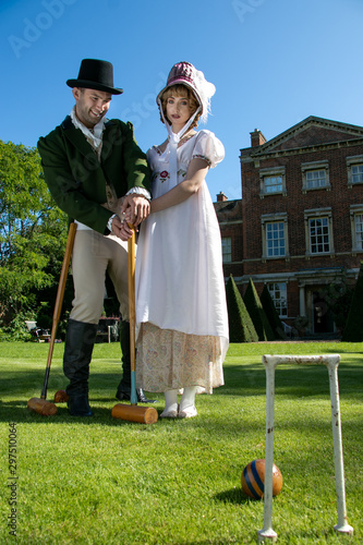Tablou pe pânză Handsome man and beautiful woman dressed in vintage clothing on lawn in front of