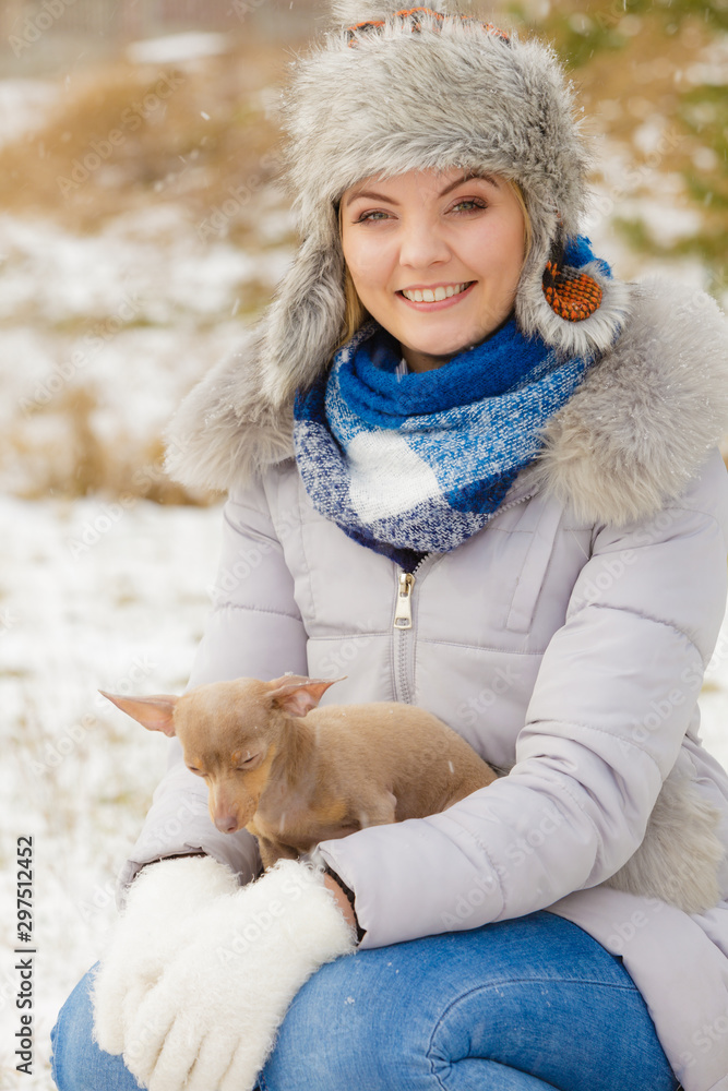 Woman playing with dog during winter Woman playing with dog during winter