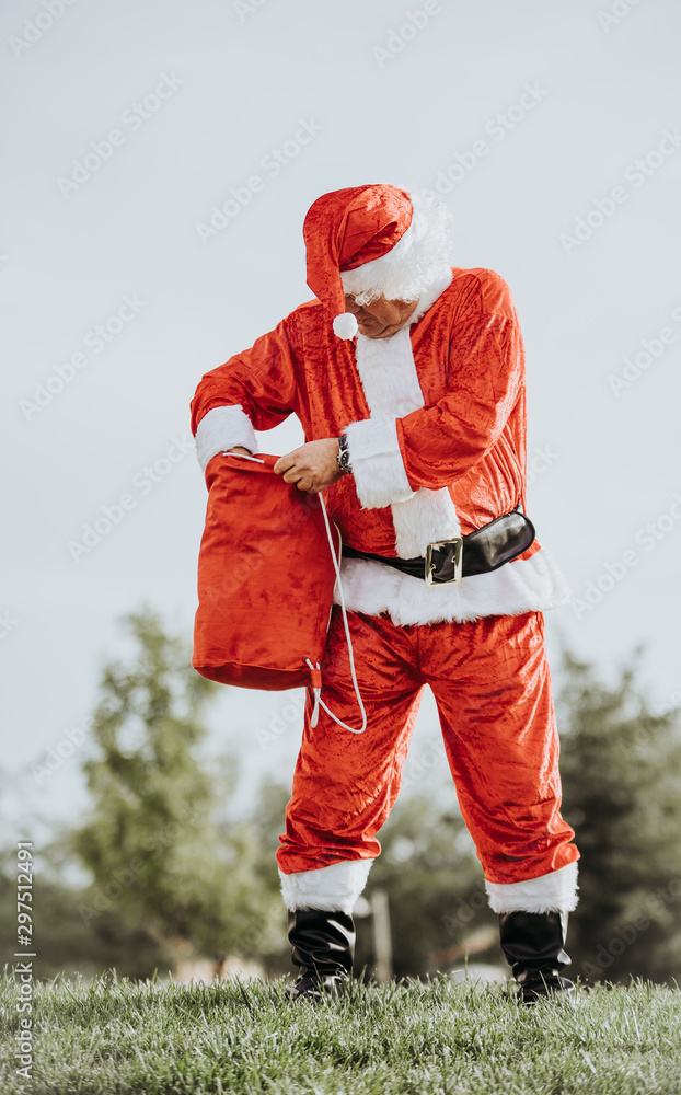 Obraz premium Stock photo of Vertical photo of papa noel without beard with arms resting on the body and yawning. Christmas time
