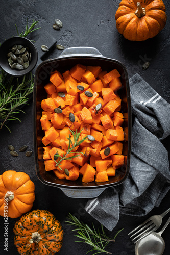 Oven baked pumpkin slices with rosemary and seeds, healthy vegetarian food, top view photo