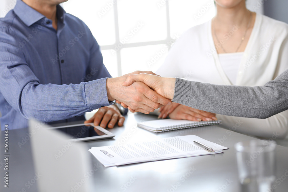 Group of business people shaking hands after discussing questions at meeting in modern office. Handshake close-up. Teamwork, partnership and agreement in business concept Group of business people shaking hands after discussing questions at meeting in modern office. Handshake close-up. Teamwork, partnership and agreement in business concept