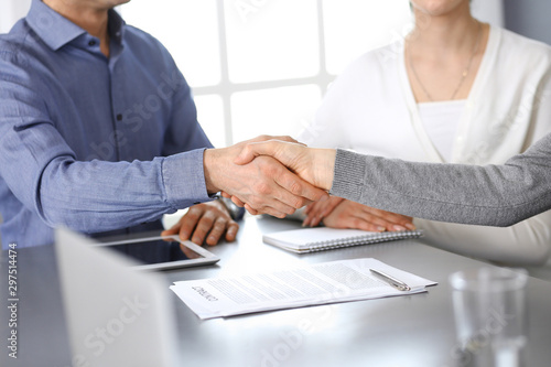 Group of business people shaking hands after discussing questions at meeting in modern office. Handshake close-up. Teamwork  partnership and agreement in business concept
