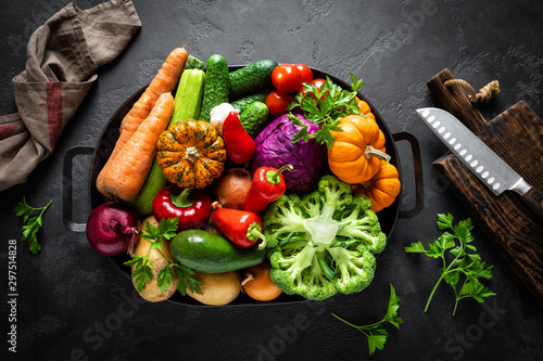 Fototapeta Naklejka Na Ścianę i Meble -  Culinary background with fresh raw vegetables on a black kitchen table, healthy vegetarian food concept, flat lay composition, top view