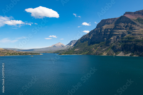 Saint Mary lake in the Glacier national park, Montana on a bright summer day with few clouds in the sky.