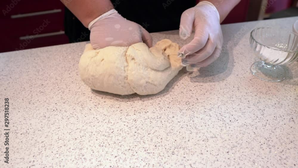 Kneading the dough as it is being prepared for a pie. A woman's hands