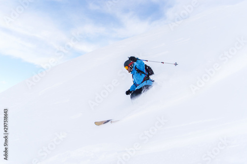 Side photo of sport man with beard skiing